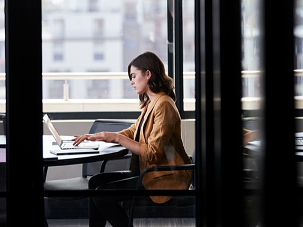 woman working on a laptop in a board room